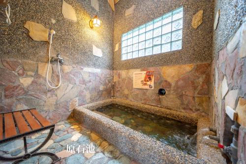 La salle de bains est pourvue d'une grande baignoire et d'une douche. dans l'établissement 一口井溫泉 One Well Hot Spring, à Jiaoxi