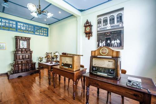 a room with two tables and a clock on the wall at WOO Gallery & Boutique hotel in Phuket Town