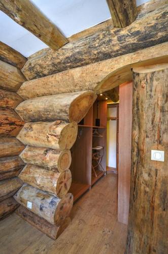 a room with a wall made out of logs at Le Chalet de Lyne in Erckartswiller