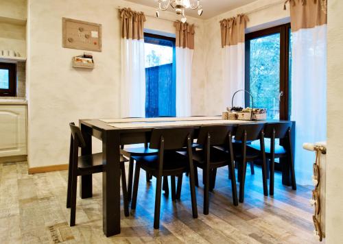 a dining room with a black table and chairs at Chalet Hovel in Mănăstirea Humorului