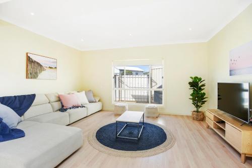 a living room with a couch and a flat screen tv at Aldinga Beach Experience - C21 SouthCoast Holidays in Aldinga Beach