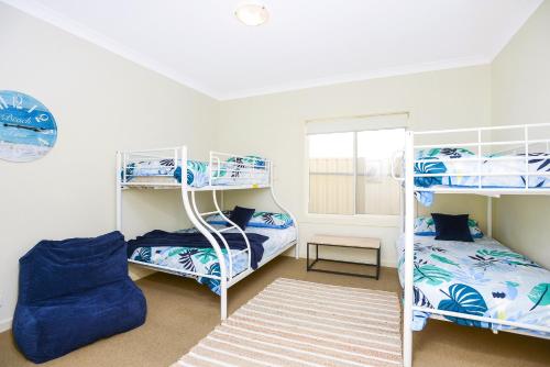 a room with two bunk beds and a chair at Aldinga Beach Experience - C21 SouthCoast Holidays in Aldinga Beach