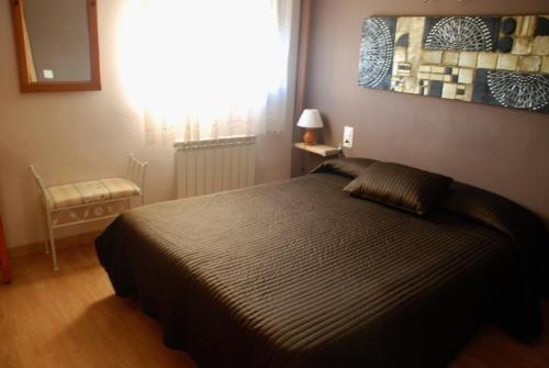 a bedroom with a bed and a painting on the wall at Hostal Delgado in Benabarre