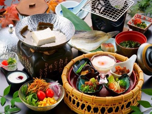 a table topped with dishes of food on a table at Seaside Hotel Mimatsu Ooetei in Beppu