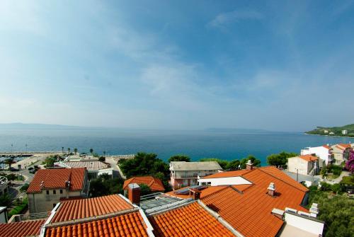 a view of a town with orange roofs and the ocean at Hotel Villa Marija in Tučepi