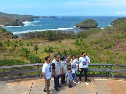 a group of people standing at the top of the doolin island sign at Desa Limasan Resort in Kalak