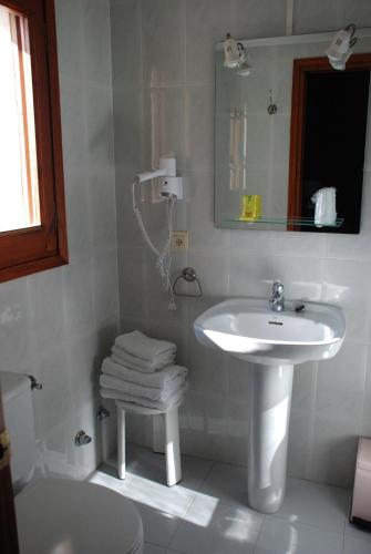 a white bathroom with a sink and a toilet at Hostal Delgado in Benabarre