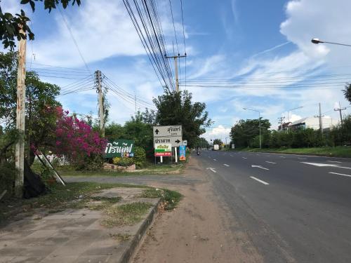 an empty street with a sign on the side of the road at Green Leaf Resort in Surin