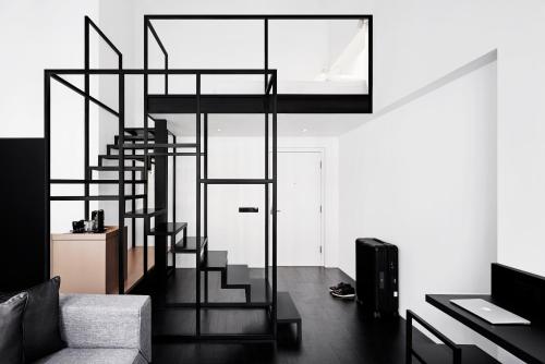 a living room with a spiral staircase in a house at Hotel Mono in Singapore