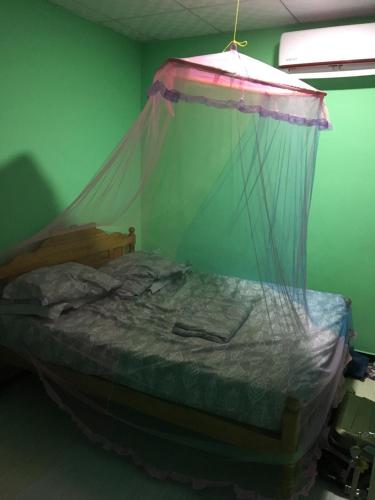 a bedroom with a bed with a mosquito net at Uthayam in Point Pedro