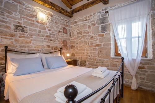 a bedroom with a bed and a brick wall at Casa Roza in Višnjan