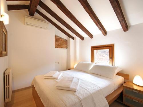 1 dormitorio con 1 cama con sábanas blancas y ventana en Mercalli II, en Milán