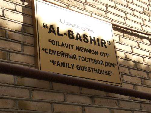 a sign on the side of a brick wall at Al-Bashir in Bukhara