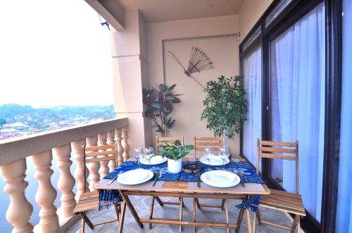 un tavolo su un balcone con tavolo e sedie di New Riverbank Suites - Waterfront Kuching City a Kuching