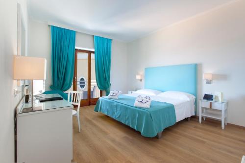 a hotel room with a bed with blue curtains at Boutique Hotel Regina in Sorrento