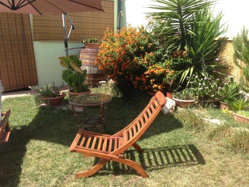 a wooden bench and a table in a garden at Lanita B&B in Càbras