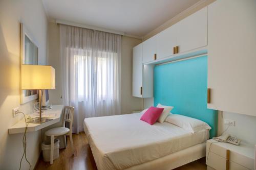 a bedroom with a bed and a desk and a window at Boutique Hotel Regina in Sorrento