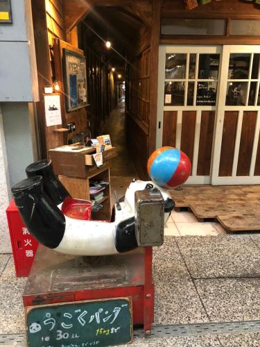 a statue of a scooter in front of a building at Onomichi Guest House Anago-no-Nedoko in Onomichi