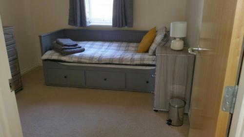 um pequeno quarto com uma cama e uma janela em Lerwick Garden Cottage em Inverness