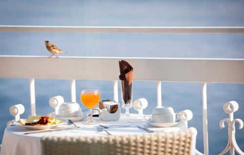 a bird standing on a table with a plate of food at Boutique Hotel Regina in Sorrento