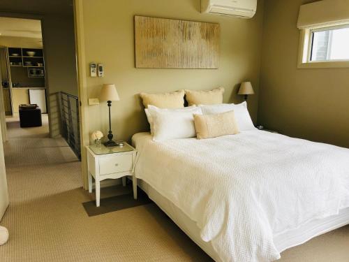a bedroom with a large white bed and a window at The Point BnB in Paynesville