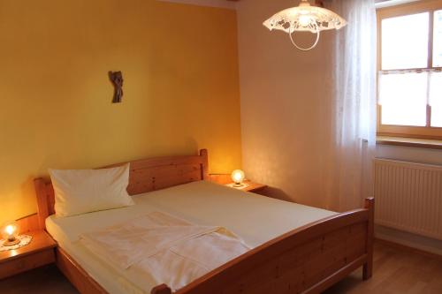 a bedroom with a bed and a chandelier at Familienferienhof Kroner in Zwiesel