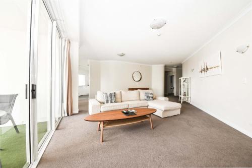 a living room with a couch and a table at Founda Gardens Apartments in Brisbane