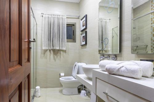 a bathroom with a toilet and a sink at Fallsway Villas in Lusaka