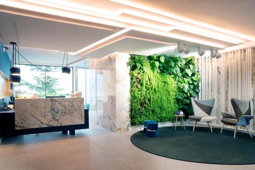 a living wall in a room with chairs and a tv at Hotel Du Lac - Relax Attitude Hotel in Brenzone sul Garda