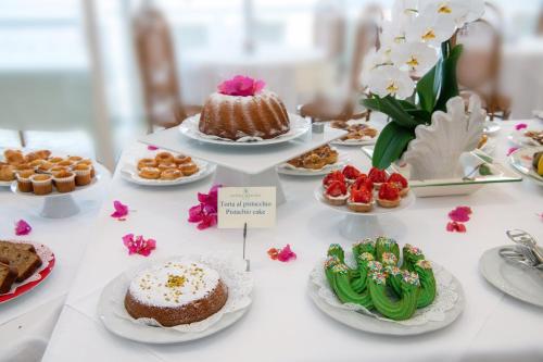 a table topped with cakes and desserts on plates at Boutique Hotel Regina in Sorrento