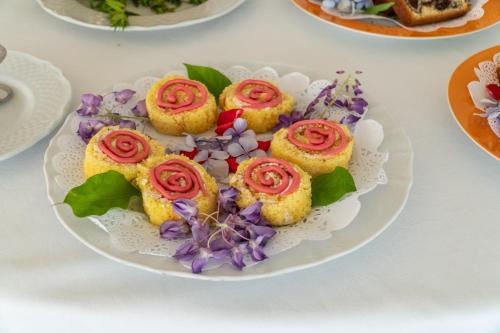 a plate of cupcakes with red roses on it at Boutique Hotel Regina in Sorrento