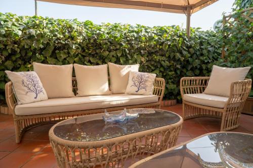 a patio with a couch and chairs and a table at Boutique Hotel Regina in Sorrento