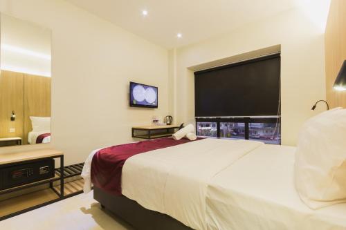 a hotel room with a large bed and a flat screen tv at GM Hotel Kuantan in Kuantan