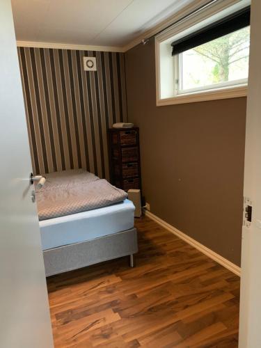 um pequeno quarto com uma cama e uma janela em Beautiful apartment in central Leknes em Leknes