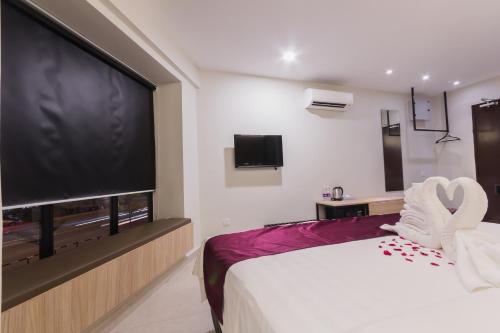 a bedroom with a large flat screen tv and a bed at GM Hotel Kuantan in Kuantan