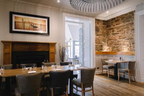 
a large dining room with a large fireplace at The Glen Mhor Apartments in Inverness
