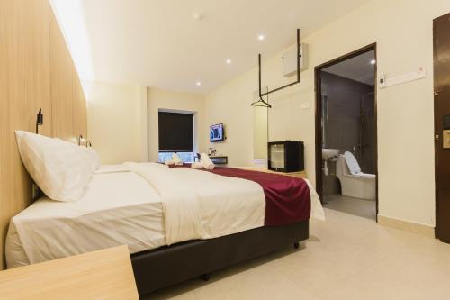 a bedroom with a large bed and a bathroom at GM Hotel Kuantan in Kuantan