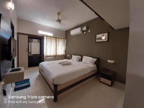 Viswa Residency by Azalea tesisinde bir odada yatak veya yataklar