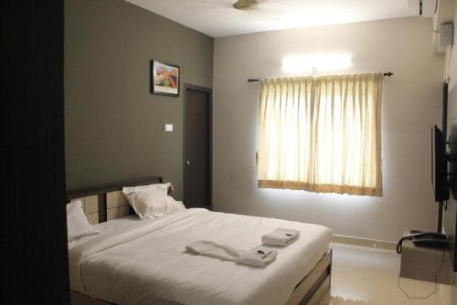 a bedroom with a bed with two towels on it at Viswa Residency by Azalea in Madurai