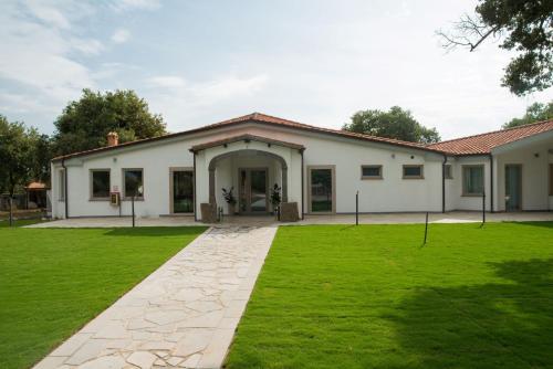 a house with a green lawn in front of it at Regia Hotel in Abbasanta