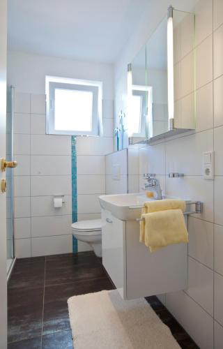 a white bathroom with a sink and a toilet at Jann-Berghaus-Straße 29 in Norderney