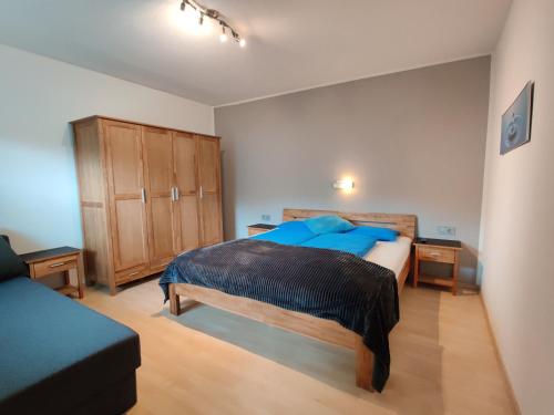 a bedroom with a blue bed and a wooden cabinet at Apartment Peer in Neustift im Stubaital
