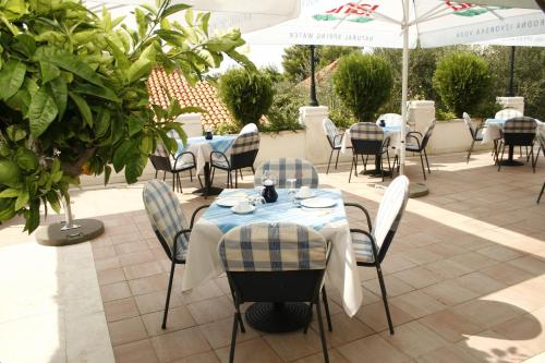 a restaurant with tables and chairs and umbrellas at Hotel Villa Marija in Tučepi