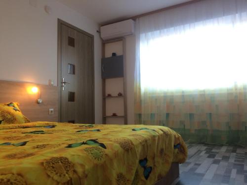 a bedroom with a bed and a large window at apartament parc cetate in Alba Iulia