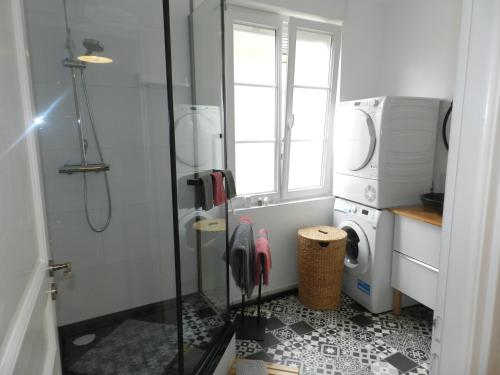 a bathroom with a shower and a washer and dryer at L IMPREVU in Chartres