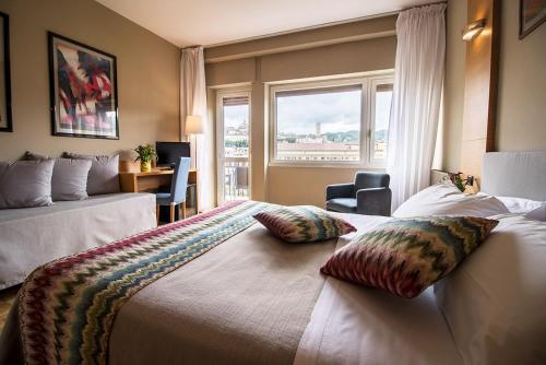a hotel room with a large bed with pillows on it at Hotel Clarici in Spoleto