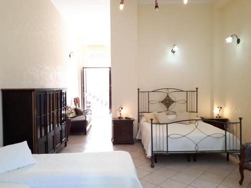 a bedroom with a bed and a couch and a chair at Casa Mia Apartment in Riposto
