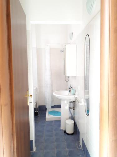 a white bathroom with a sink and a toilet at Casa Mia Apartment in Riposto