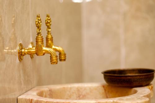 een badkamer met een gouden wastafel en een kom bij Birgi Rukim Otel in Birgi