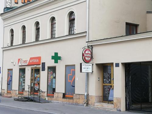 un bâtiment blanc avec une pharmacie dans une rue dans l'établissement Lorf Hostel&Coffee, à Cracovie